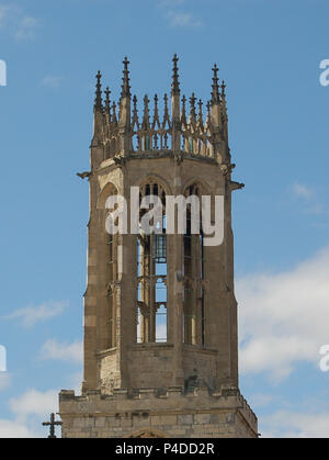 Una delle antiche guglie di York Minster Abbey agianst un blu cielo nuvoloso Foto Stock