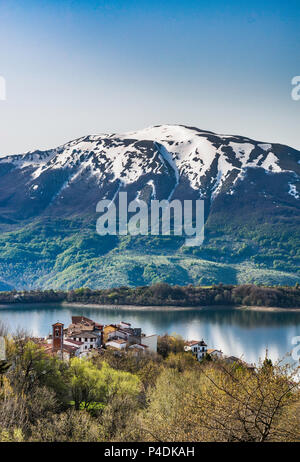 Villaggio di Mascioni oltre il Lago di Compotosto, del Gran Sasso d'Italia la gamma della montagna di distanza, fine aprile, Gran Sasso Laga National Park, Abruzzo, Italia Foto Stock