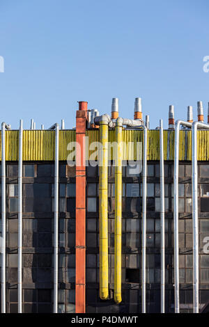 Ventilazione e tubi di condizionamento sul tetto dell'edificio industriale contro il cielo blu sullo sfondo Foto Stock