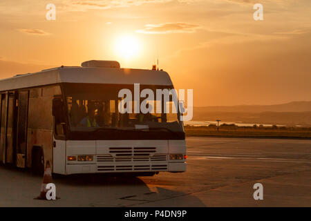 Bus navetta alla fermata dell'aeroporto i raggi del sole al tramonto Foto Stock