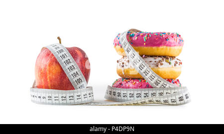 Red apple e tre ciambelle colorato avvolto in un sarti nastro di misurazione isolata su bianco. Foto Stock