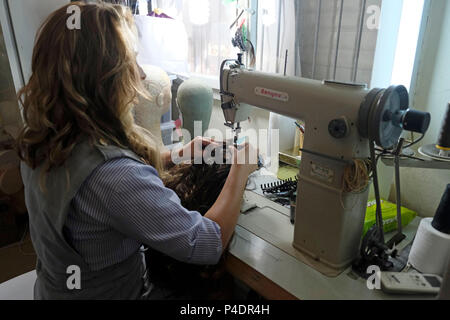 Una giovane donna Haredi lavora su una parrucca presso il laboratorio di Bracha Keynan, un produttore di parrucche e stilista haredi nella città di Bnei Brak o bene Beraq, un centro del giudaismo Haredi in Israele Foto Stock