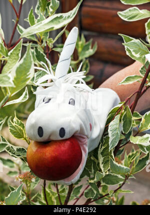 Giocattolo bianco sul lato unicorn con Apple Foto Stock