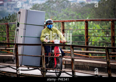 Hanoi, Vietnam - Marzo 15, 2018: uomo vietnamita di trasportare un enorme frigorifero sulla sua moto Foto Stock