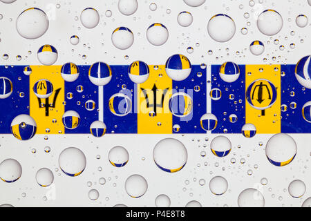 Bandiere di Barbados dietro un vetro ricoperto di gocce di pioggia. Foto Stock
