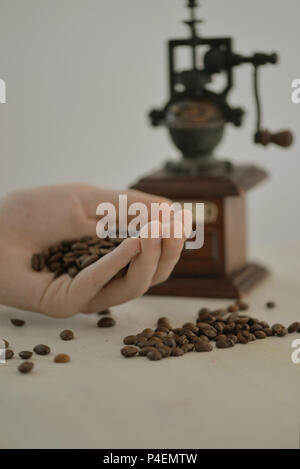 L'uomo la mano che regge il caffè torrefatto in grani Foto Stock