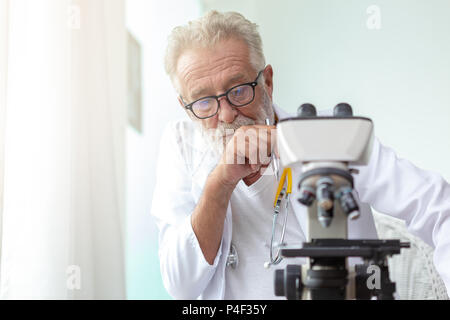 Medico i vecchi o gravemente scienziato che lavora con un microscopio in laboratorio. Foto Stock