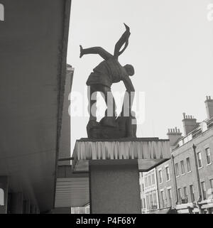 Anni sessanta, storico al di fuori del frony del Palazzo dei Congressi, il quartier generale del Sindacato congresso (TUC) è la scultura da Bernard prati raffigurante il forte aiutando il debole, che rappresenta lo spirito del movimento sindacale, Londra, Inghilterra, Regno Unito. Foto Stock