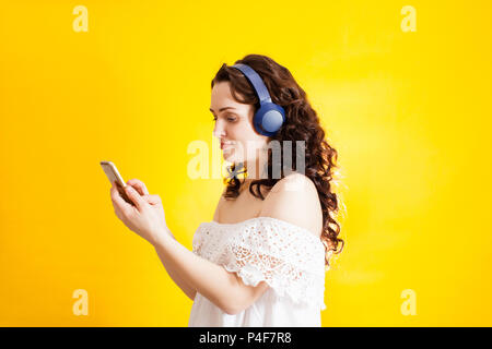 Giovane ragazza che indossa le cuffie wireless Foto Stock