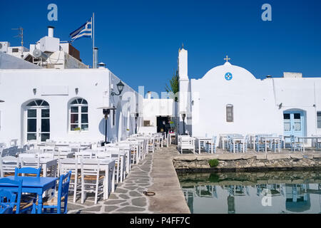 Tipica taverna greca tabelle nella pittoresca città di Naoussa, isola di Paros, Cicladi Grecia Foto Stock