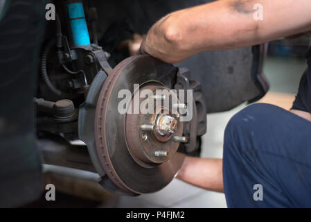 Close up meccanico di automobili riparazione di pastiglie del freno Foto Stock