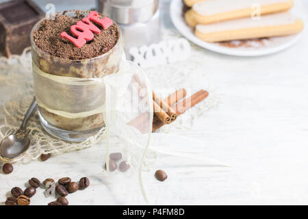 In casa il tiramisù in vetro con cioccolato, i chicchi di caffè e biscotti savoyardi. Copyspace Foto Stock