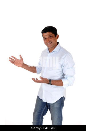 Una buona ricerca East Indian man standing in jeans e la luce maglietta blu con mani tese, isolato per sfondo bianco Foto Stock