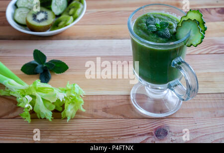 Sul tavolo in un recipiente di vetro a basso contenuto calorico realizzato frullato di cetriolo, sedano, mele e kiwi, progettato per la dieta a perdita di peso. Foto Stock