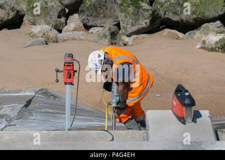 Thornton Cleveleys Lancashire, Regno Unito. Il 22 giugno 2018. Un cielo azzurro e sole sulla costa di Fylde come operai da Balfour Beatty eseguire seawall riparazioni per le difese costiere di riflessione d'onda parete. Tecnici e ingegneri provenienti da una società di costruzioni accusato dai consiglieri locali di botching quattro anni di regime in Blackpool e a quale costo £27.1m, dopo giochi formati tra le sezioni di calcestruzzo parete del mare a causa di danni causati dall'acqua e pannelli che mostrano segni di erosione. Balfour Beatty si è detto consapevole di perdita di acqua da una giunzione fra sezioni di cemento verso la parte nord del proiettore Anchorsholme difesa. Foto Stock