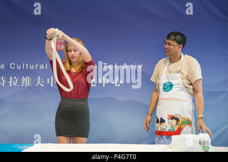 Tel Aviv, Israele. Il 22 giugno, 2018. Una ragazza israeliana (L) impara a base di noodle rendendo abilità durante un cinese food festival evento presso il il Centro Culturale Cinese di Tel Aviv, Israele, il 22 giugno 2018. Credito: Guo Yu/Xinhua/Alamy Live News Foto Stock