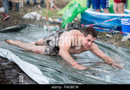 22 giugno 2018, Germania, Scheeßel: Niklas salti su una slitta di acqua nel campeggio dell'Hurricane Festival. 65.000 visitatori partecipare alla Open Air Festival dal 22 fino al 24 di giugno. Foto: Hauke-Christian Dittrich/dpa Foto Stock