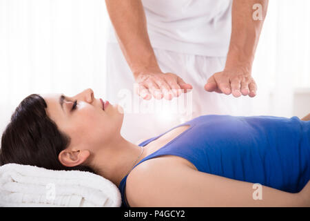 Close-up di una rilassata atmosfera giovane donna avente reiki guarigione il trattamento Foto Stock