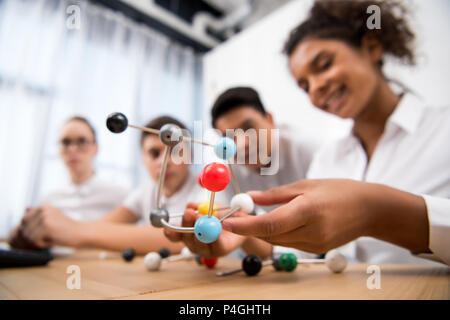 I giovani studenti di prelievo modello molecolare per la lezione di Chimica Foto Stock