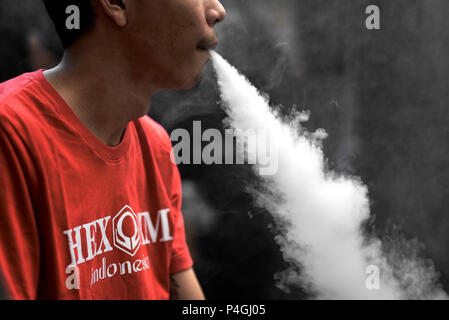 Sigaretta elettronica utente esala vapore durante una fiera vaping a Jakarta, Indonesia. Foto Stock