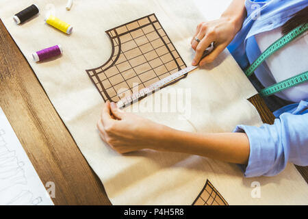 Immagine ritagliata della sarta modello di misurazione a tavola Foto Stock