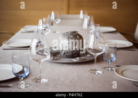 Vista ravvicinata della disposizione delle posate, decorazioni e wineglasses vuota sul tavolo nel ristorante Foto Stock