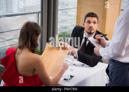 Messa a fuoco selettiva dell'uomo facendo ordine su San Valentino romantico data con la fidanzata in ristorante Foto Stock