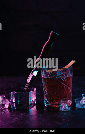 Vista ravvicinata di vetro con deliziose bevande boulevardier cocktail e cubetti di ghiaccio Foto Stock