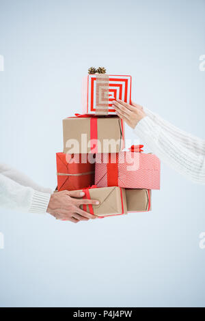 Ritagliato shot della giovane azienda pila di avvolgere i regali di Natale isolato su grigio Foto Stock