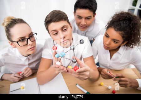 I giovani studenti di prelievo modello molecolare per la lezione di Chimica Foto Stock
