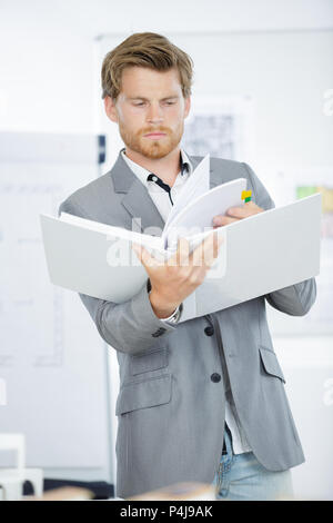 Fiducioso designer di sesso maschile in possesso di una cartella in ufficio creativo Foto Stock
