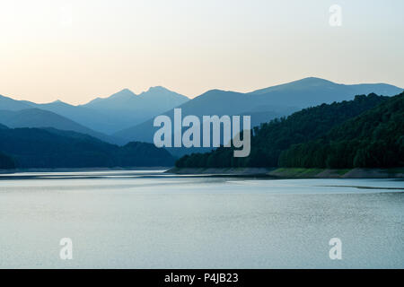 Lago tranquillo al tramonto. Il lago di Vidraru è un lago artificiale in montagna Fagaras, Arges county, Romania Foto Stock