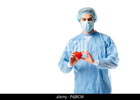 Cardiologo indossando uniforme blu e tenendo toy cuore isolato su bianco Foto Stock