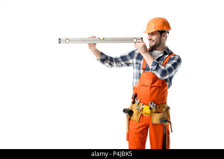 Giovani repairman in arancione nel complesso il controllo livello di spirito isolato su bianco Foto Stock