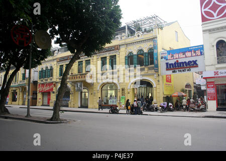 Fila di giallo vetrine in stile coloniale con persiane verdi, Hanoi, Vietnam Foto Stock