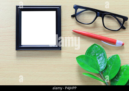 Vintage photo frame e occhiali vicino a penna rossa posta su marrone con pavimento in legno e dispone di spazio di copia per il design nel suo concetto di lavoro. Foto Stock