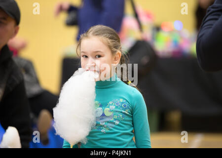 La Bielorussia, Gomel, il 10 marzo 2018. I bambini di vacanza all'apertura del negozio Caravan.La ragazza è mangiare dolci cotone ariosa.dolce lana di cotone a ea Foto Stock