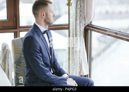 Elegante lo sposo in una camera di hotel Foto Stock