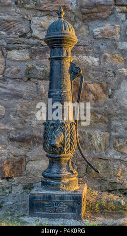 Questo elegante in ghisa a balaustra della pompa a mano si appoggia contro una parete di fronte ad un blocco di appartamenti, appena fuori dalla piazza principale nel villaggio di nerezza, sul souther Foto Stock