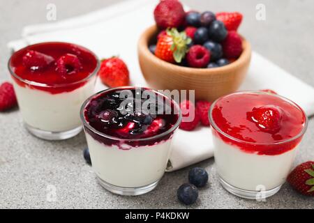 Diversi bicchieri di vetro di yogurt con frutta di bosco marmellata di frutti di bosco e bacche Foto Stock