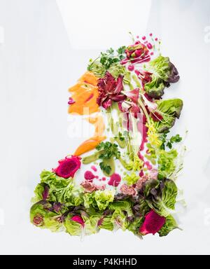 Un ritratto di una donna realizzata da Lattuga, la frutta e la verdura su una superficie bianca Foto Stock
