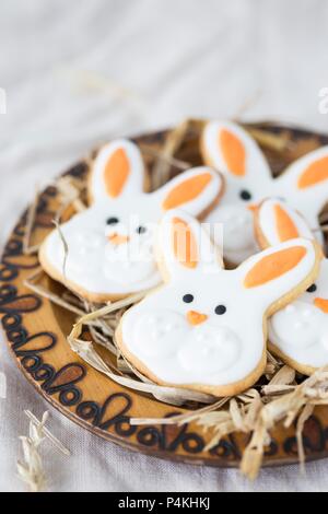 Coniglietto di pasqua i cookie su un piatto di legno con paglia Foto Stock