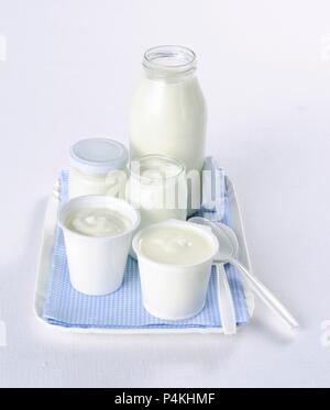 Yogurt in un assortimento di bicchieri e tazze Foto Stock