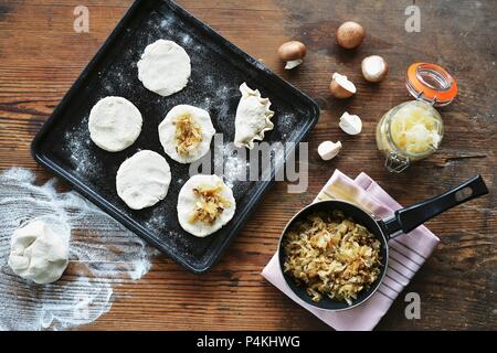 Maultaschen (tedesco piatto di pasta) su una placca da forno con la pasta e gli ingredienti accanto ad esso Foto Stock