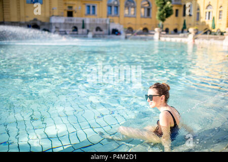 Ungheria, Budapest - 21 Maggio 2018: giovane donna rilassante con getto di acqua in il famoso Szechenyi bagni termali di Budapest. Si tratta di uno dei più grandi nat Foto Stock