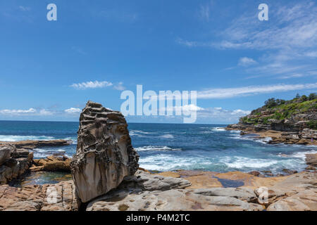 Sydney Bondi Beach bay con surfers nuoto nelle onde e scogliere intorno alla baia Foto Stock