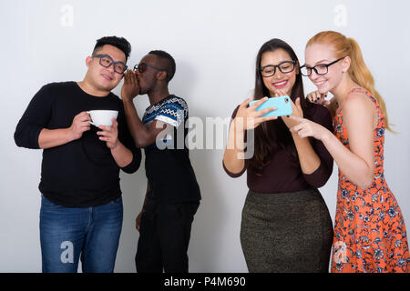 Felice gruppo diversificato di multi etnico amici sorridere mentre usando Foto Stock