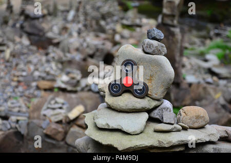 Un filatore in legno si trova su strane strutture di pietra nella foresta Foto Stock