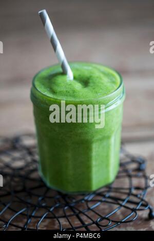 Un frullato di verde in una vite-top jar con una paglia Foto Stock