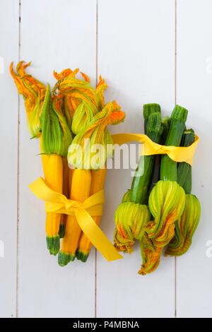 I grappoli di giallo e verde di zucchina con fiori, legati in un nastro Foto Stock